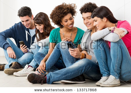 stock-photo-group-of-happy-young-friends-looking-at-cell-phone-133717868